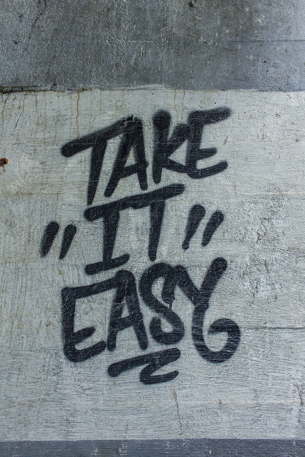 Graffiti on the wall saying "Take it easy".