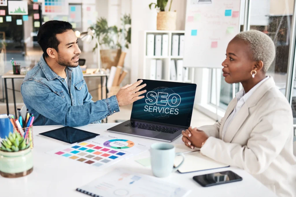 Marketing team discussing SEO audit strategies during a business presentation with a laptop.