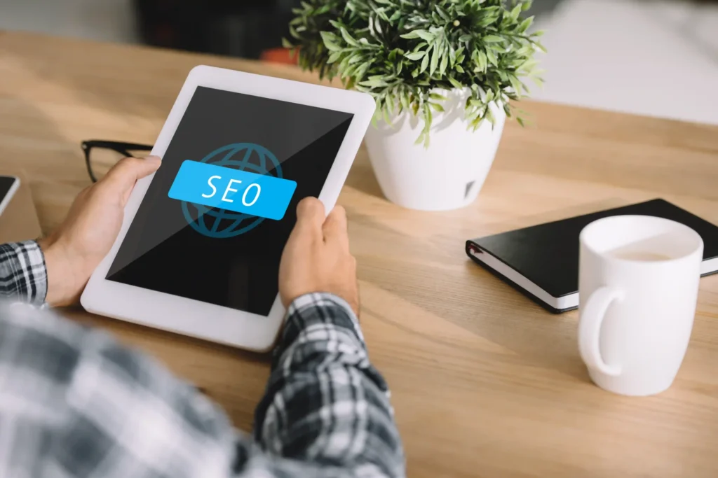 Person holding a tablet with an SEO icon, symbolizing digital strategy for on page SEO recommendations