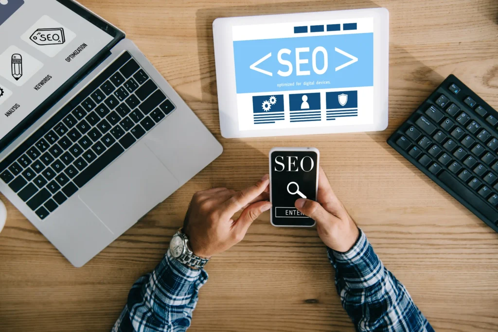 Professional working on E-commerce SEO strategy using multiple digital devices and dashboards.