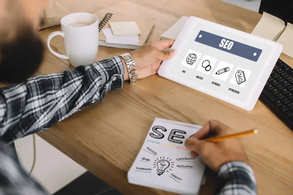 Professional SEO specialist sketching out technical SEO work strategies with a tablet and notes
