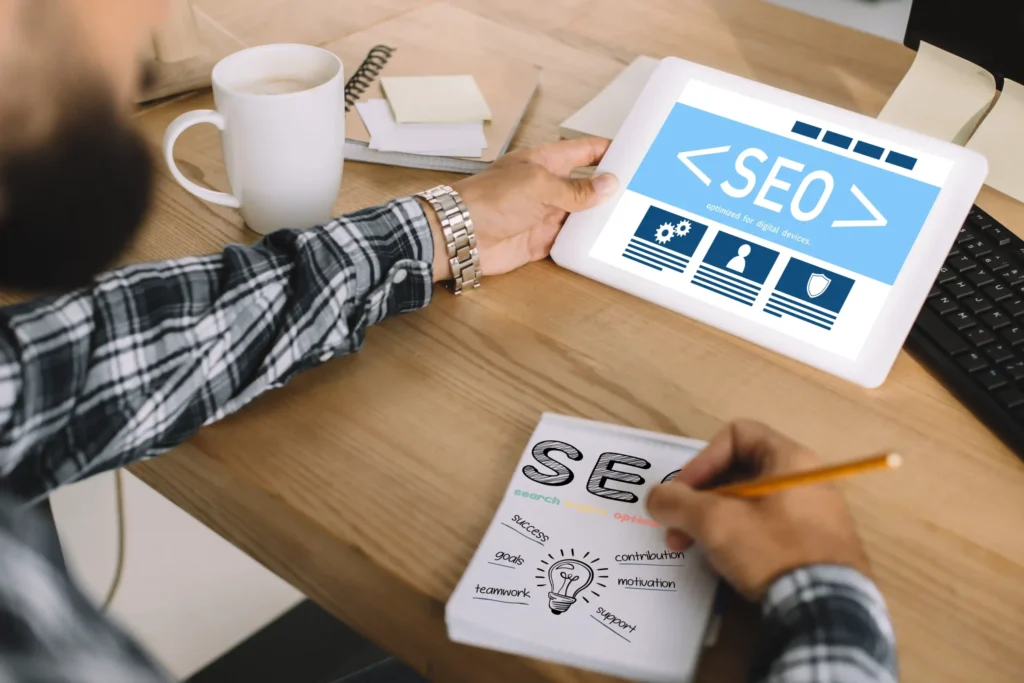 SEO expert planning technical SEO parts with tablet and written notes.