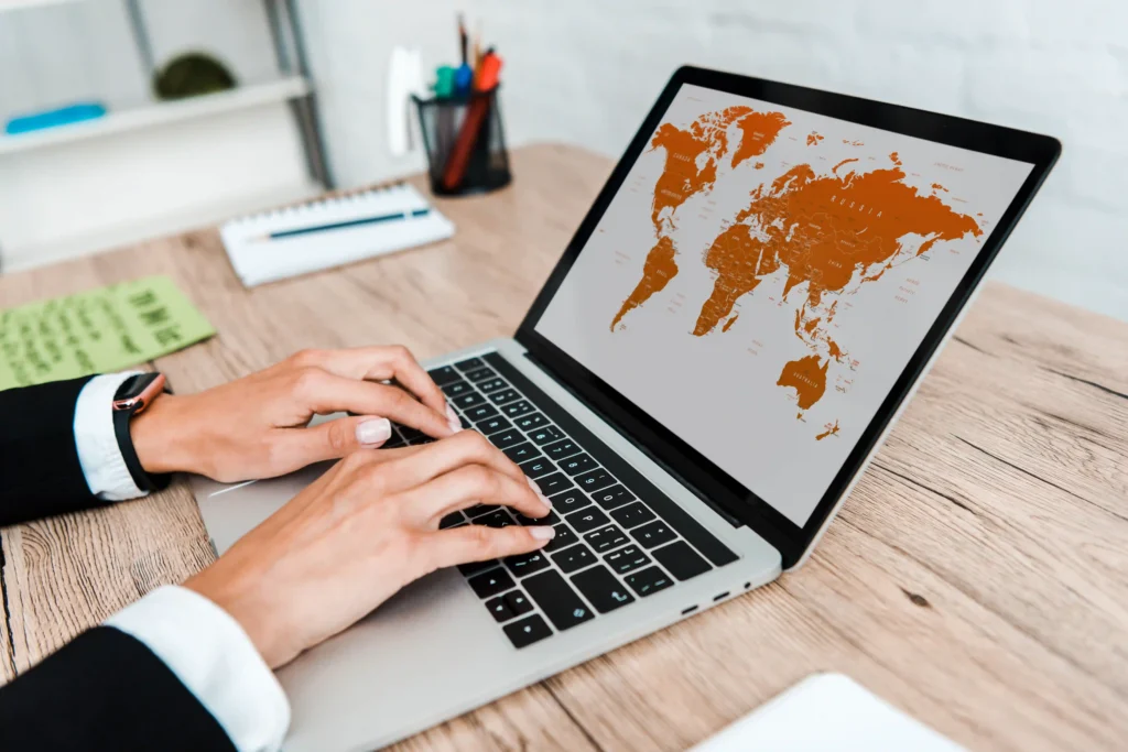 Businesswoman working on International SEO using a laptop with a world map interface