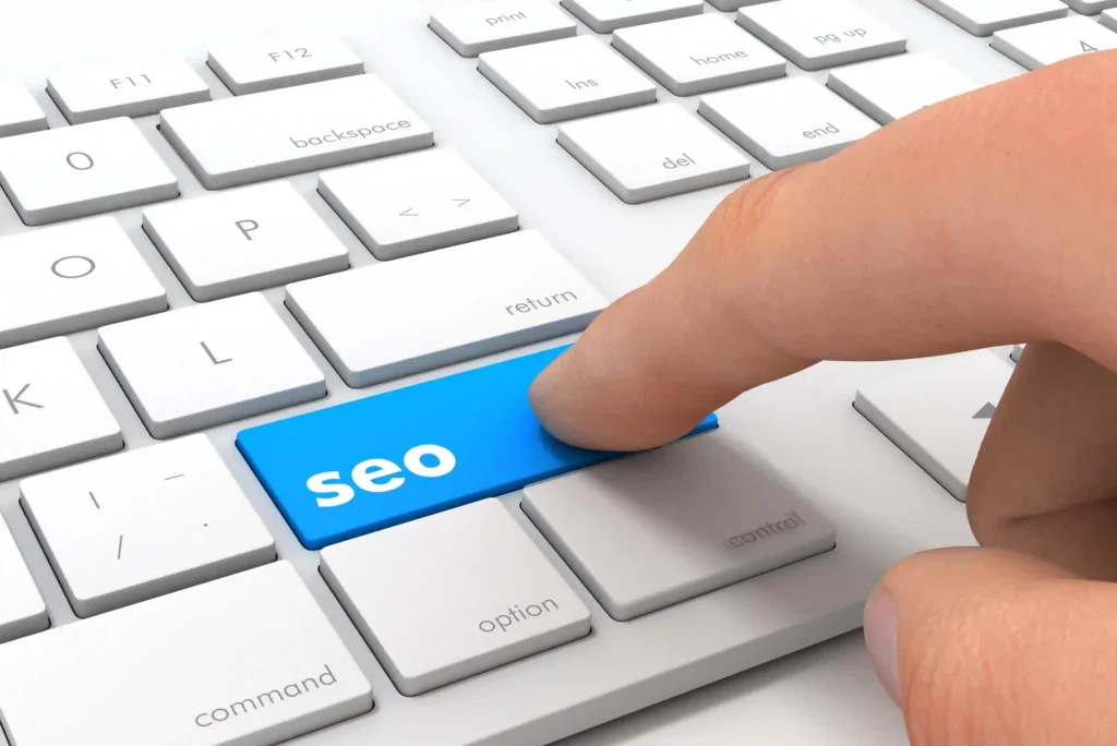 Close-up of a keyboard with a finger pressing a bright blue "SEO" button — symbolizing the start of on page seo learning.