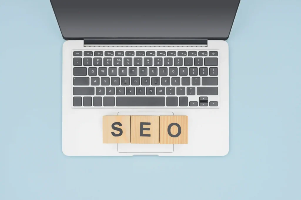 Minimalist top view of a laptop with SEO cubes, symbolizing keyword planning for on page SEO video strategies.