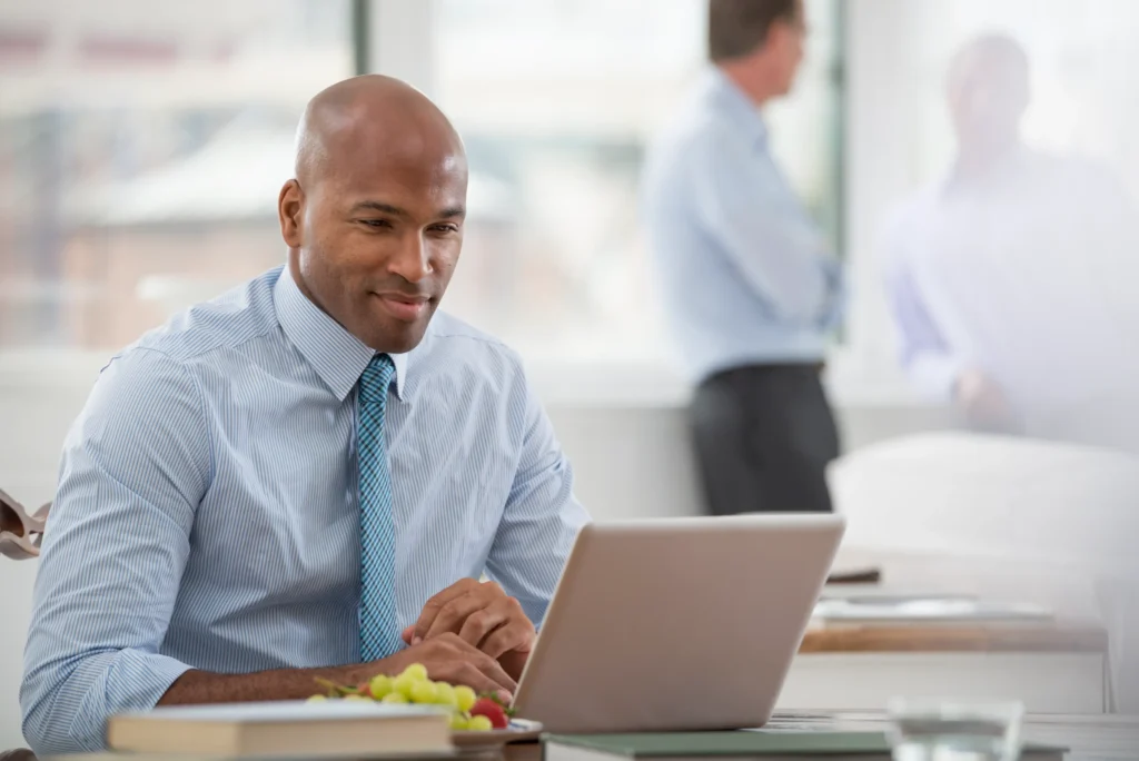 A professional businessman working on a laptop in an office, focused on SEO strategy and analytics.