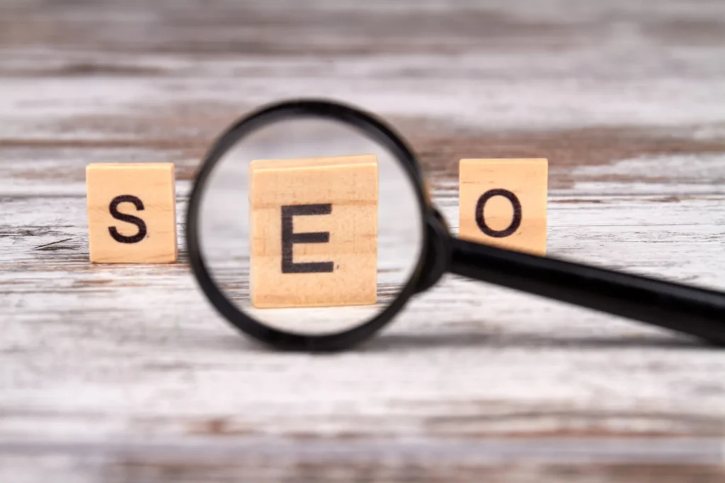 SEO spelled out with wooden blocks and magnifying glass, used for ecommerce SEO interview questions.