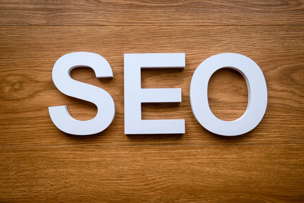 Minimalist image of white SEO letters symbolizing focus on core SEO marketing objectives on a wood surface.