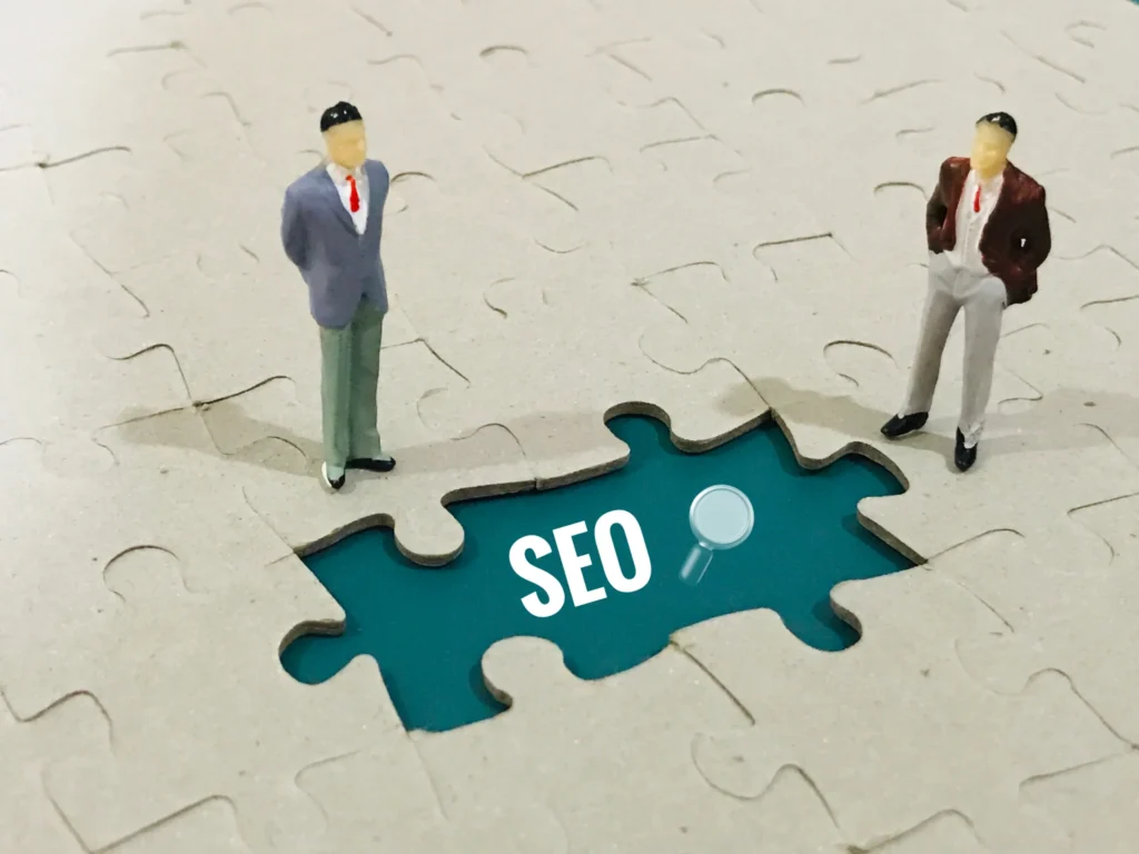 Two miniature figures standing near puzzle piece labeled SEO, symbolizing strategy in digital marketing in 5 minutes.