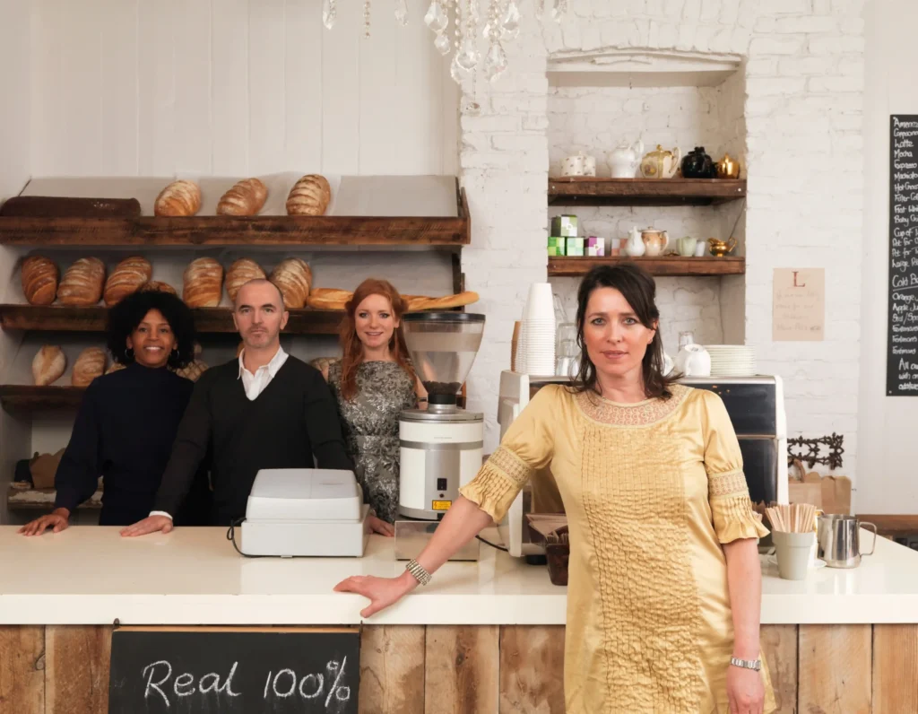 Team of restaurant owners and staff posing inside a bakery, representing restaurant social media marketing companies focused on brand storytelling.