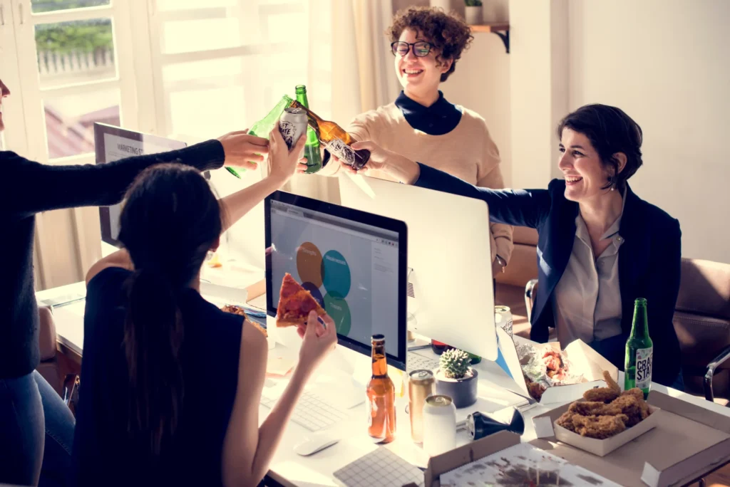 Marketing team celebrating success while planning a marketing strategy for food business in modern office.