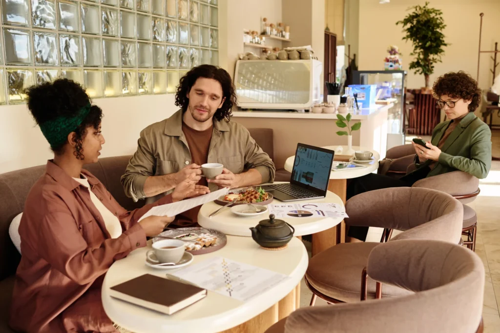 Team meeting in a cozy café planning smm for restaurants campaigns and content strategy.