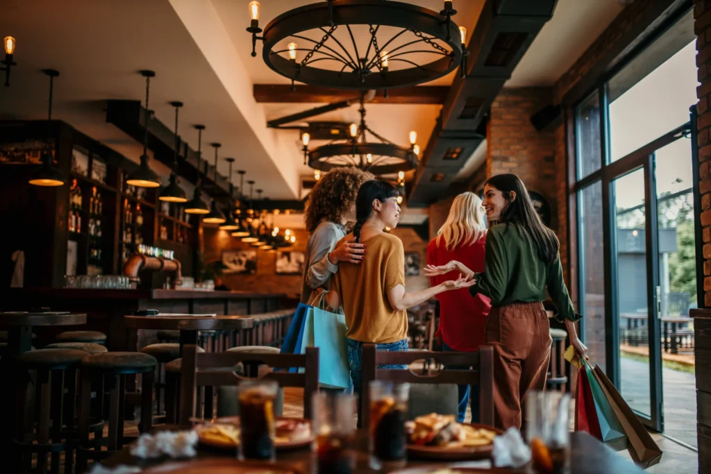 Friends chatting and walking inside a modern restaurant, symbolizing the success of restaurant search engine marketing campaigns.