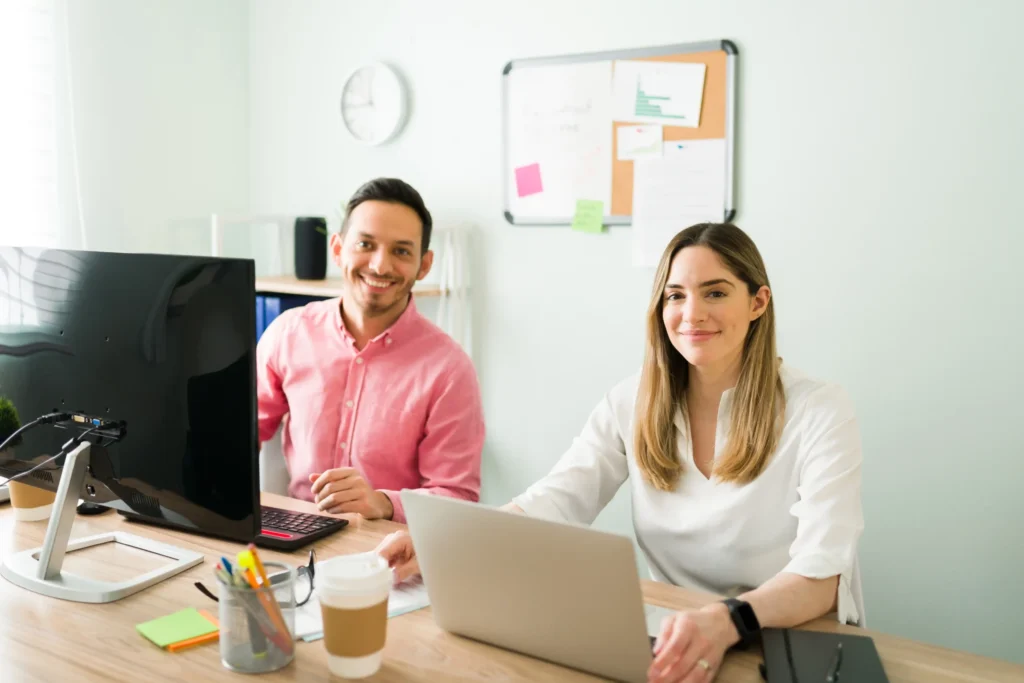 Smiling marketing professionals working together in a bright office at an affordable digital marketing company.