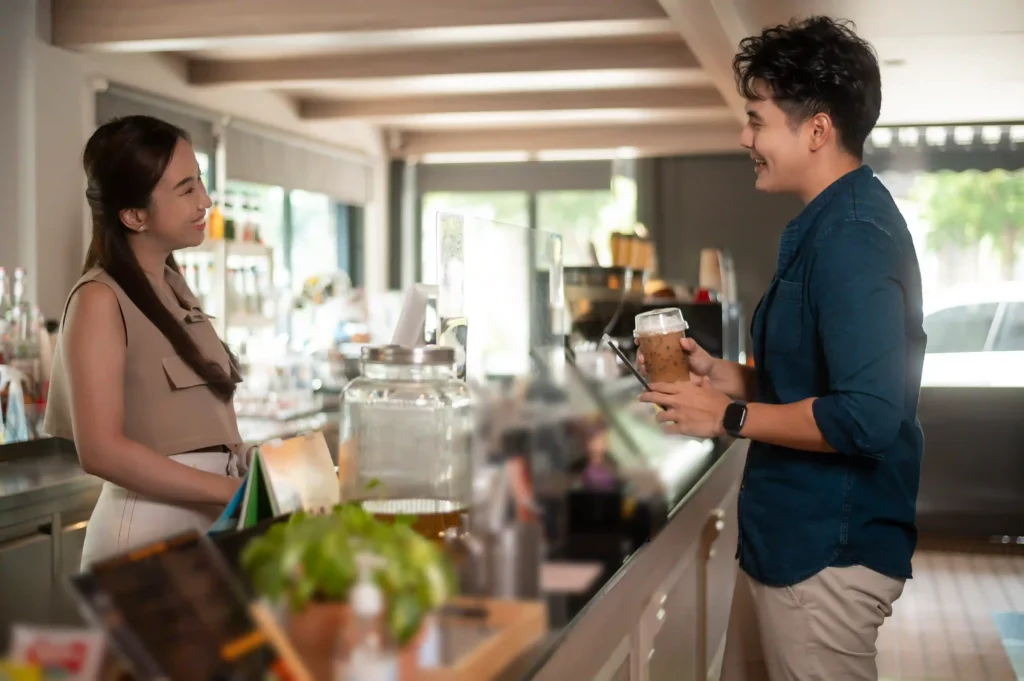 Barista and customer sharing a friendly moment while discussing menu choices, capturing the heart of cafe advertising ideas.