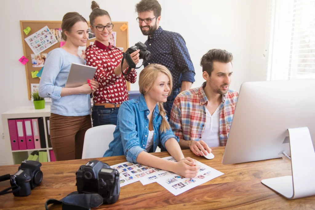 A creative team collaborating on photo and design projects inside a digital content agency workspace.