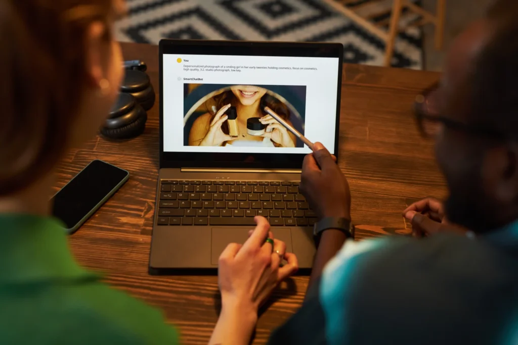 Two marketers reviewing content strategy on a laptop while discussing improvements for an online marketing website.