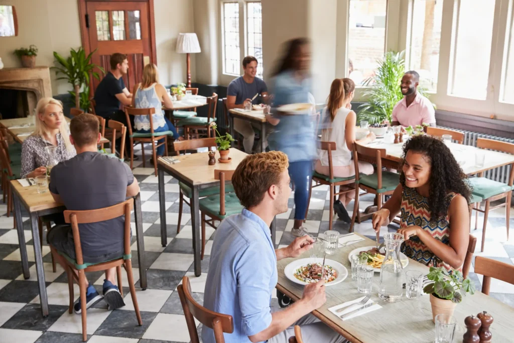 Busy restaurant with happy customers enjoying meals, highlighting success through the best restaurant marketing campaigns.