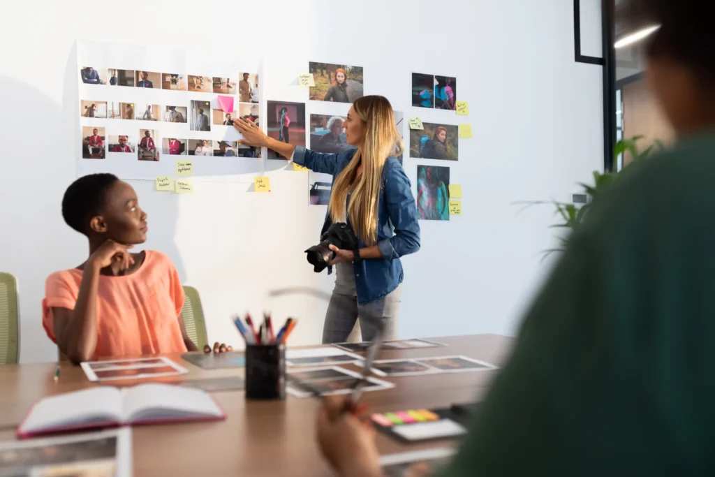 Marketing team reviewing visual concepts on a wall during a creative strategy meeting, representing collaboration used by the best performance marketing agencies.