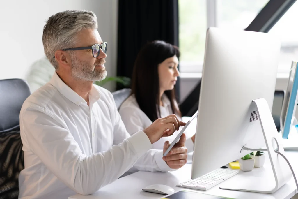 Experienced designers collaborating on digital website design at a desktop workstation, focusing on user experience and modern layouts.