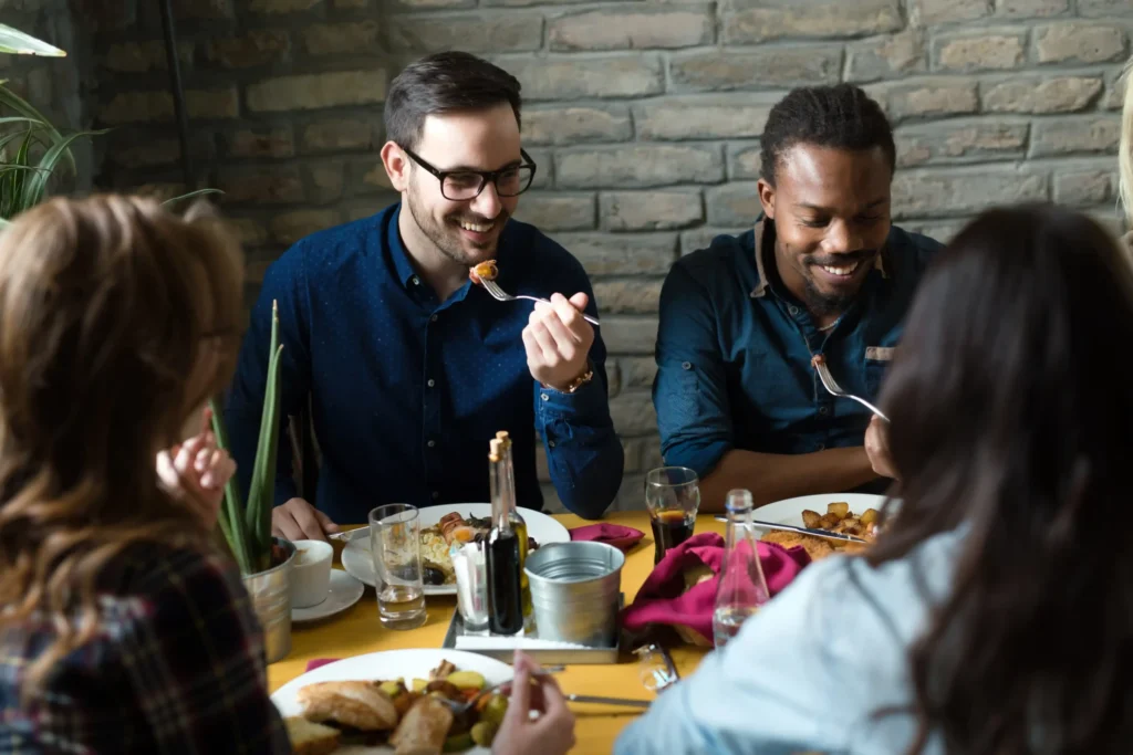 Happy group of business professionals dining together showing the importance of community building in a social media strategy for restaurant.