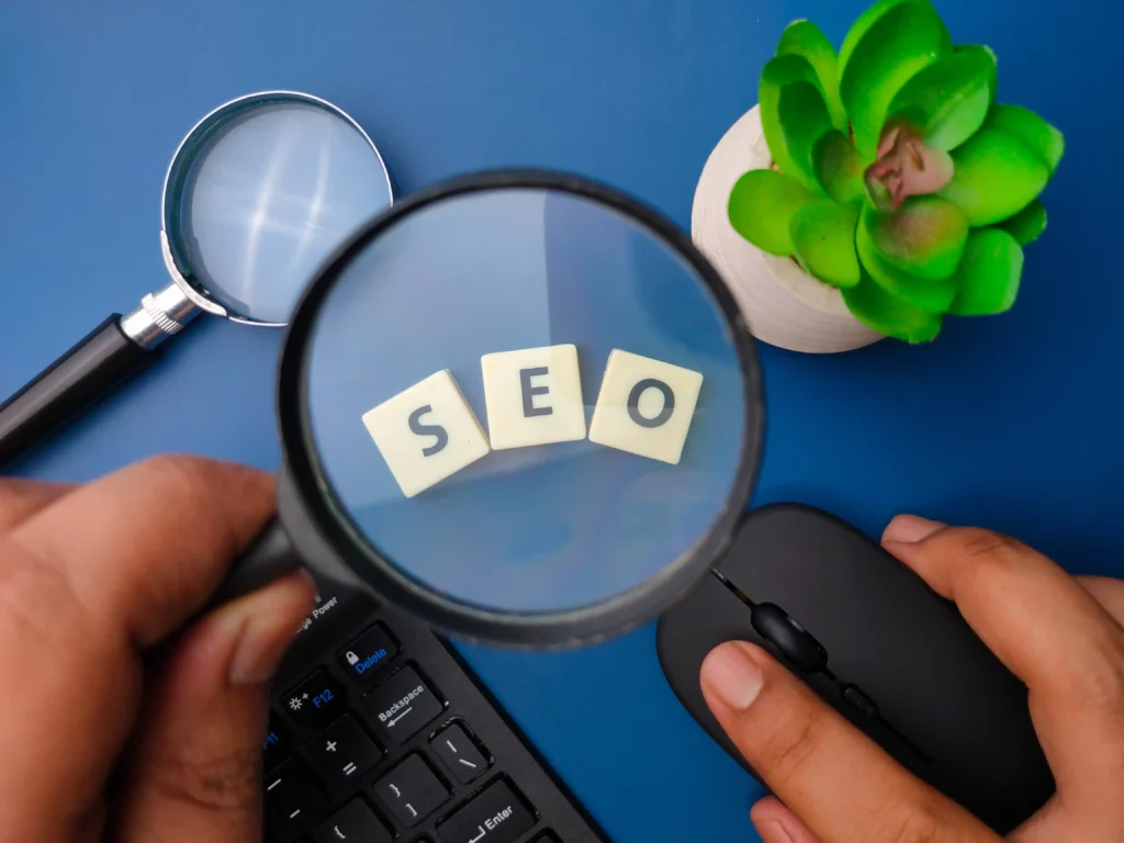 Close-up of magnifying glass focusing on SEO tiles representing analysis and research behind local SEO services cost.