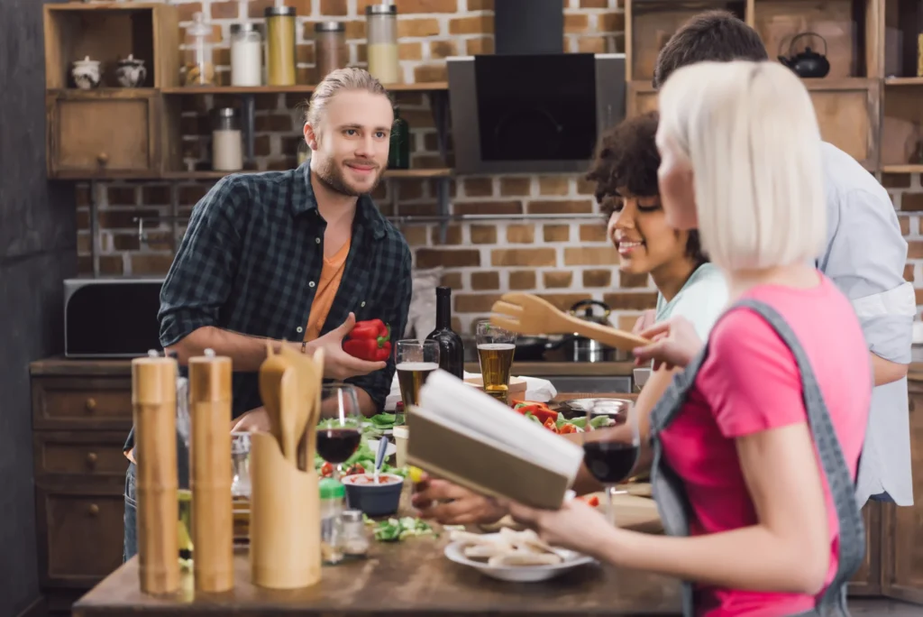 Group of diverse friends preparing food in a kitchen, highlighting community-focused content ideas used in restaurants online marketing.