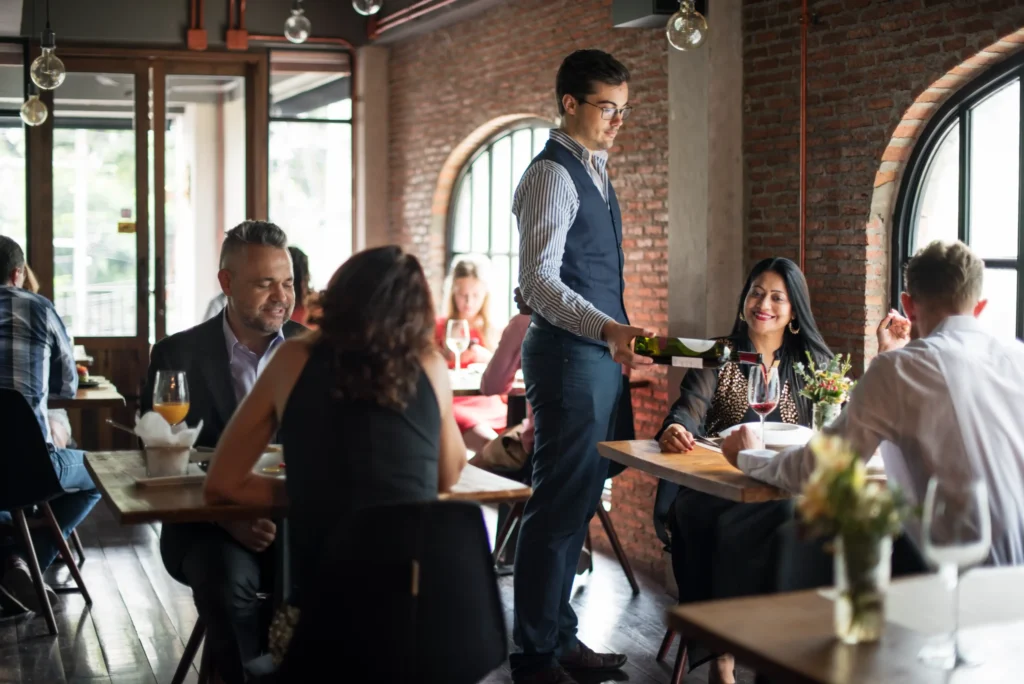 Guests enjoying wine and dinner in a modern upscale restaurant, showcasing real customer behavior for restaurant market research insights.