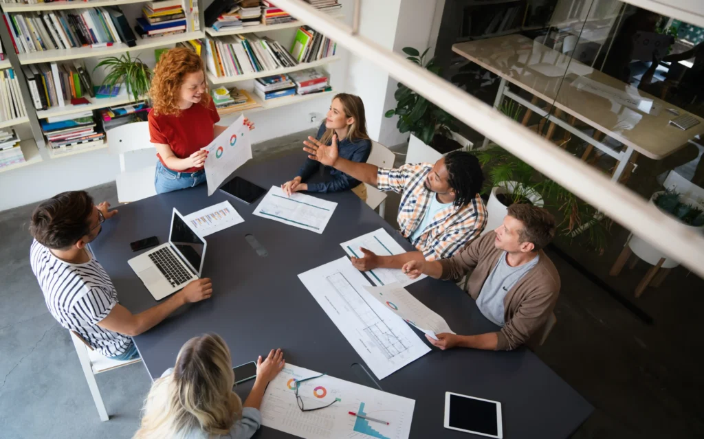 Diverse marketing professionals in a meeting discussing reports and performance in local SEO for agencies.