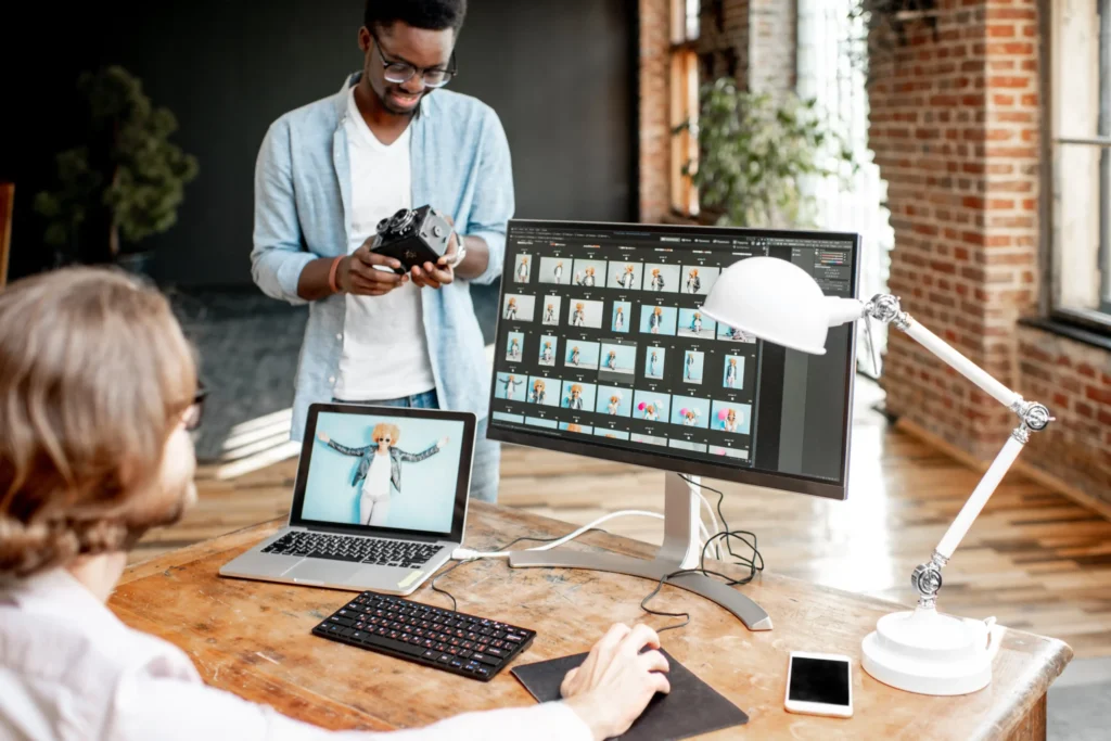 eam editing photos on large monitors inside a creative workspace at a content production agency