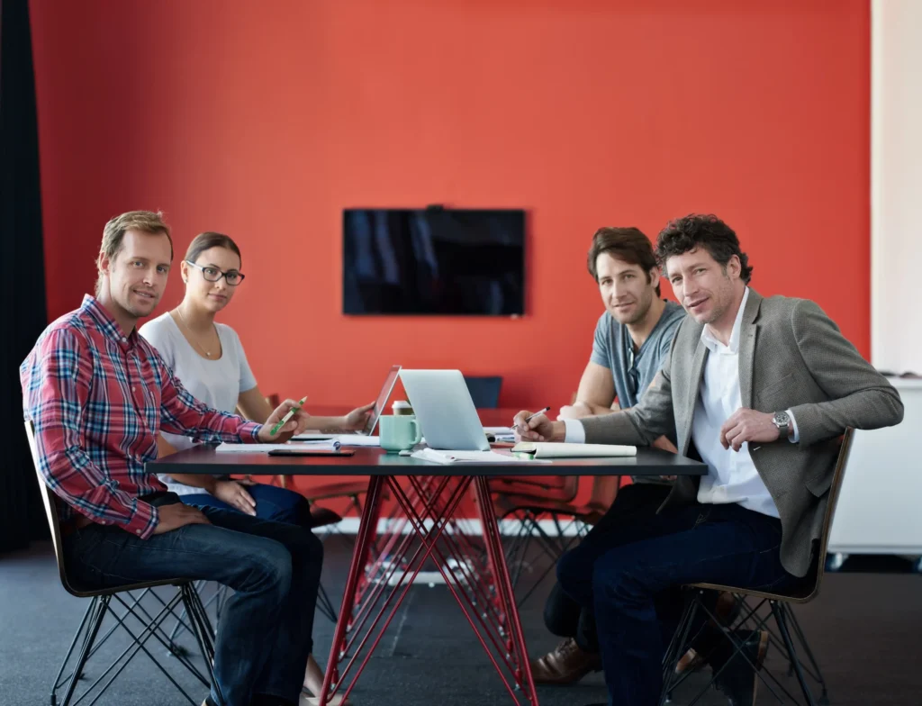 Group of professionals planning digital marketing strategies in a creative workspace, representing a social media marketing agency for restaurants.