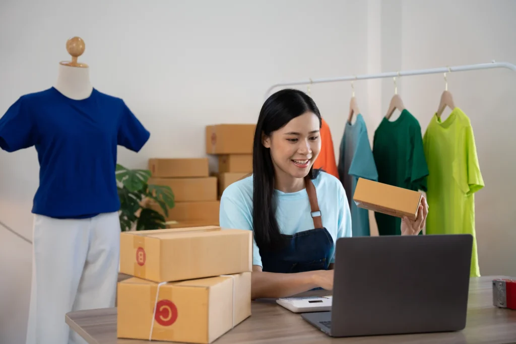A woman managing her online clothing store and packaging products, showcasing how local SEO for ecommerce drives visibility.