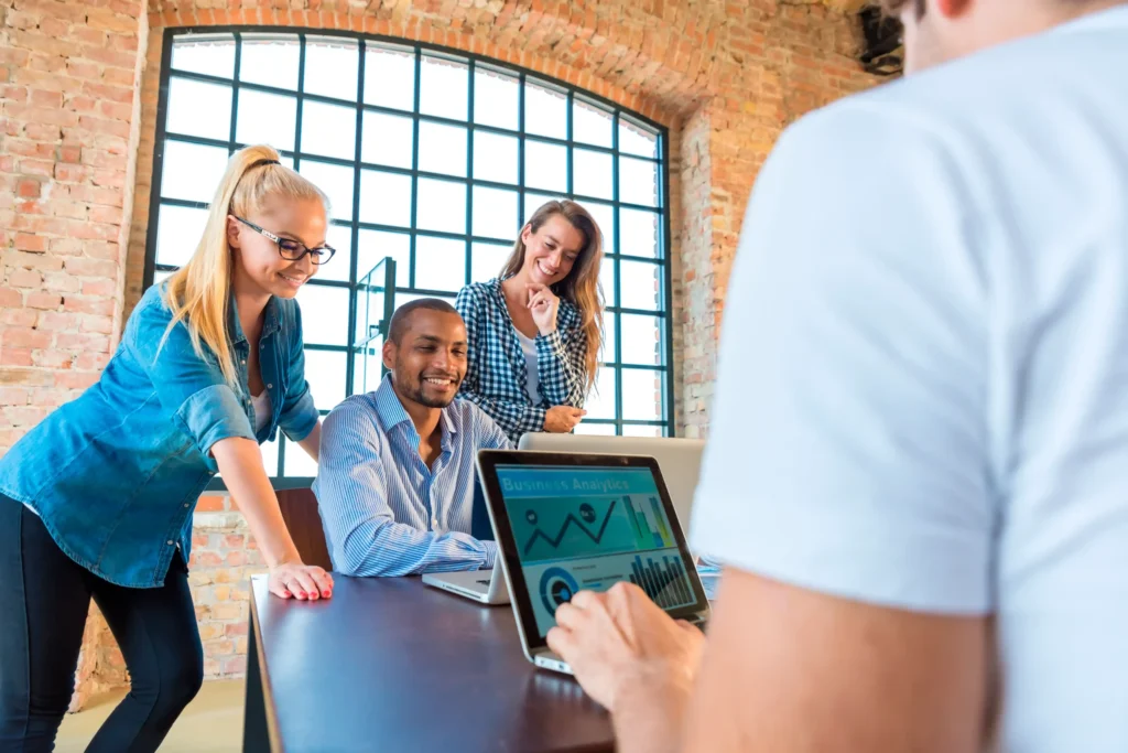 Marketing team reviewing business analytics together in a modern office setting, representing real teamwork inside a digital performance marketing agency focused on data-driven growth.