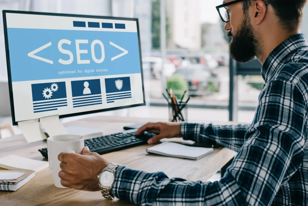 Digital marketer working on desktop computer displaying SEO interface as part of SEO digital marketing services.