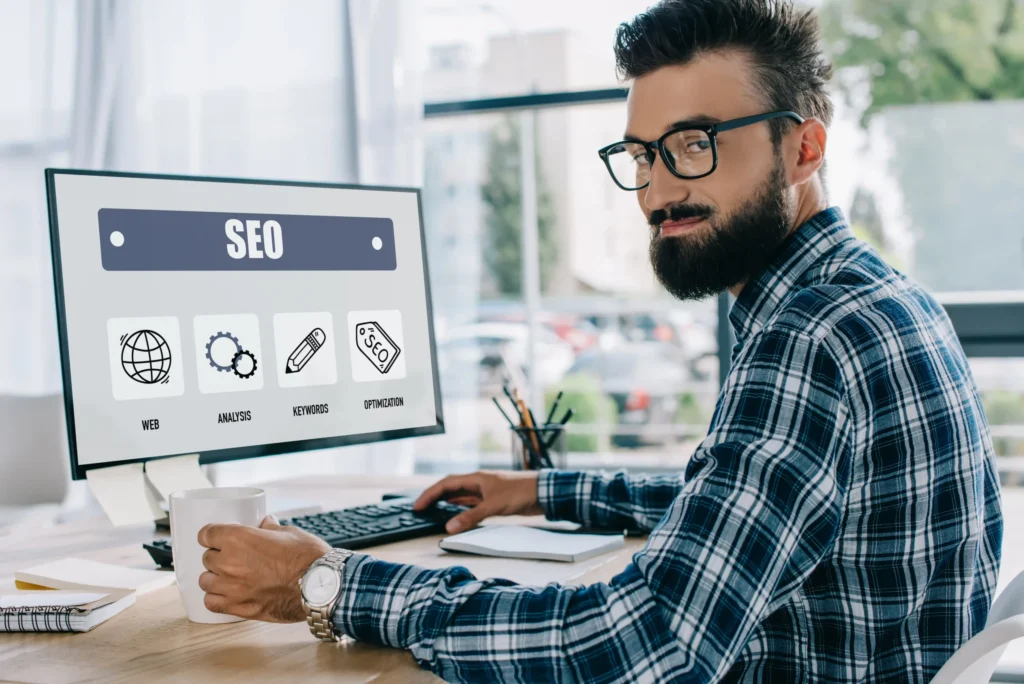 SEO specialist working at a desktop computer with optimization icons, representing search engine optimization advertising strategies.