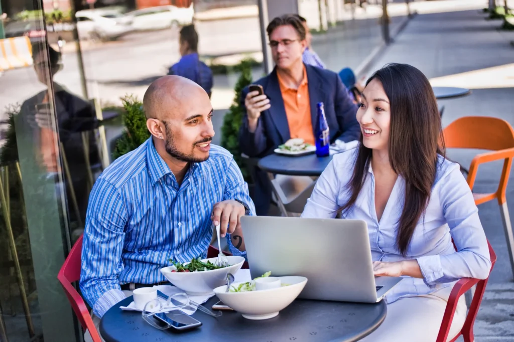Restaurant marketing firms discussing growth strategies with a restaurant owner at an outdoor café