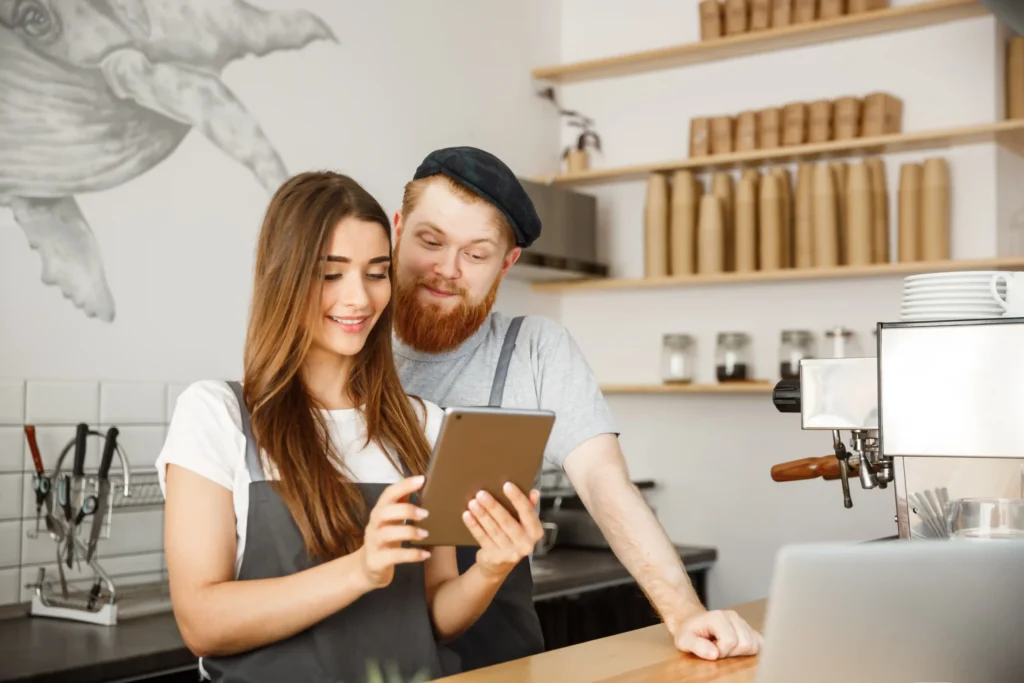 Small business owners looking at a tablet while planning marketing tasks related to local SEO link building.