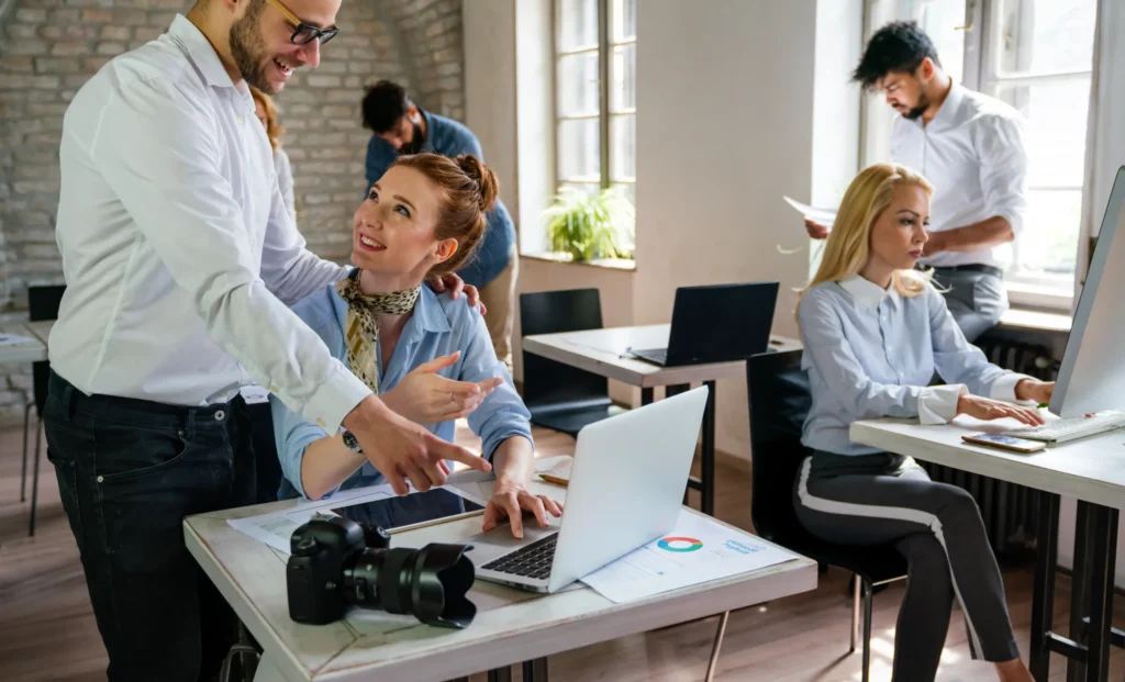Team of professionals collaborating in an office environment at an online digital marketing agency, reviewing data, content, and campaign performance.