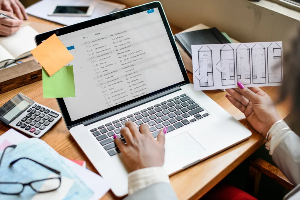 Person checking an email inbox while reviewing documents, demonstrating workflow organization for email marketing for restaurants.