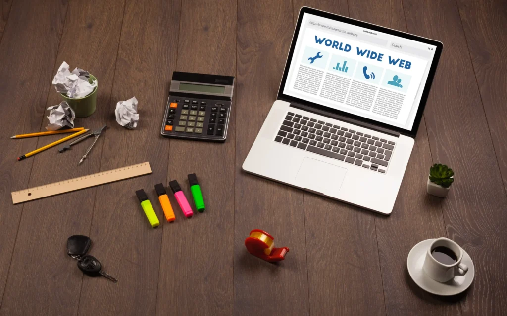 digital marketing agency website design workspace with laptop, office tools, and creative marketing materials on desk