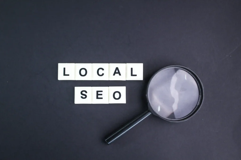 Magnifying glass placed beside blocks spelling local SEO, illustrating how local SEO link building improves visibility.
