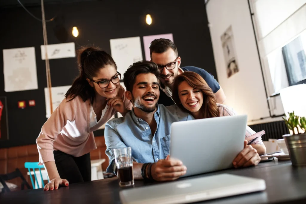 Creative team working together at a digital website agency, reviewing design and strategy on a laptop.