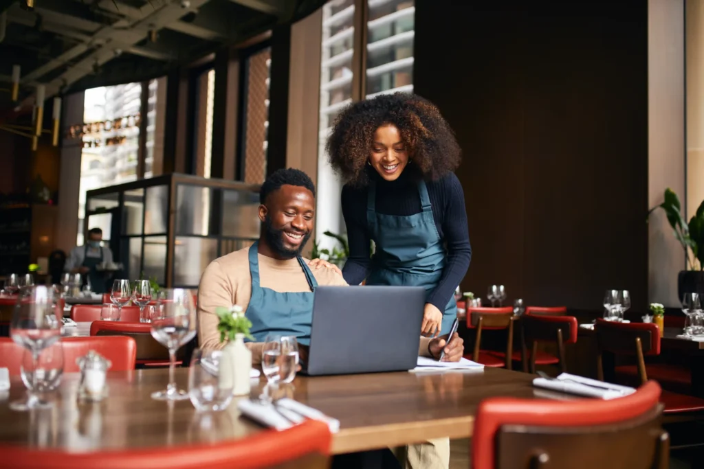 Digital marketing for restaurant operations shown as restaurant owners review online marketing performance and business data on a laptop