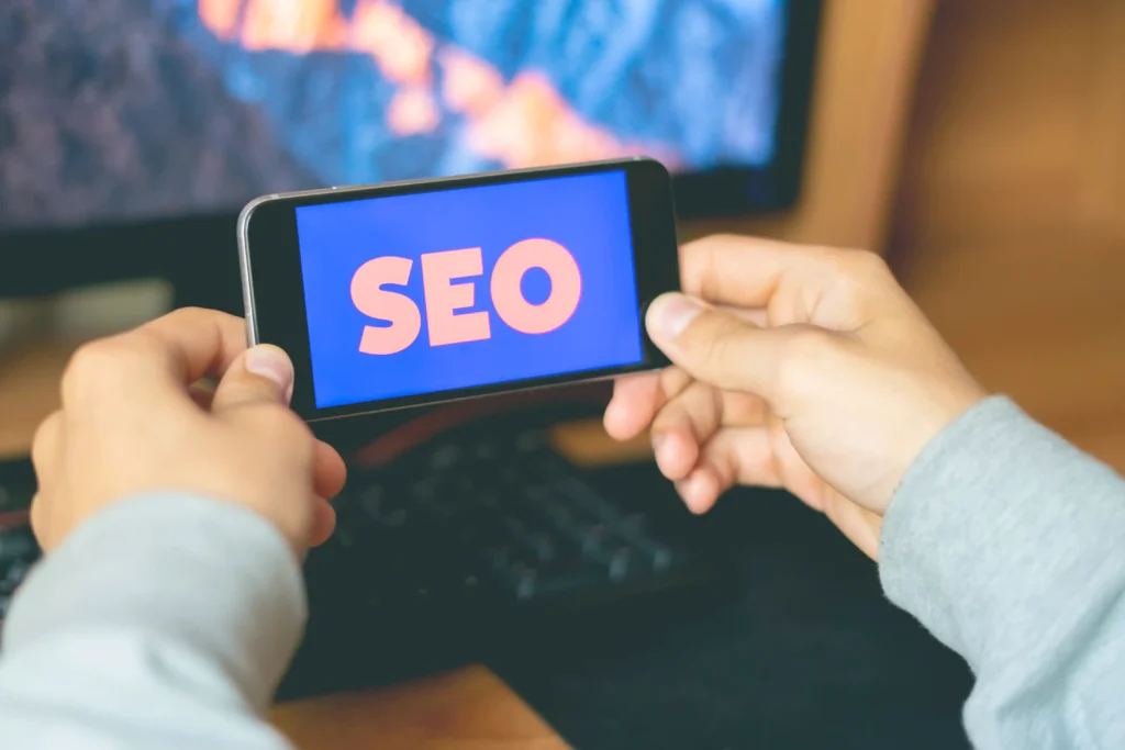 Person holding a smartphone displaying the word SEO while researching local seo services pricing options and costs.